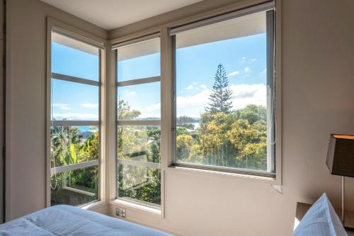 a bedroom with a window with a view at The Sands - Apartment 5 - Stay Waiheke in Onetangi