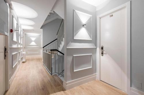a hallway with a staircase and a white door at Hostal Los Ángeles in Madrid
