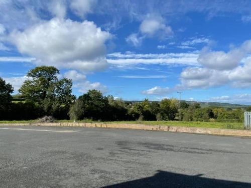 an empty road with a blue sky and clouds at Shepherds Gate at The Royal Oak Much Marcle in Preston