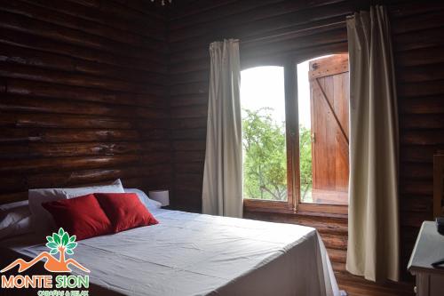 a bedroom with a bed and a large window at Monte Sion cabañas & relax in San Javier