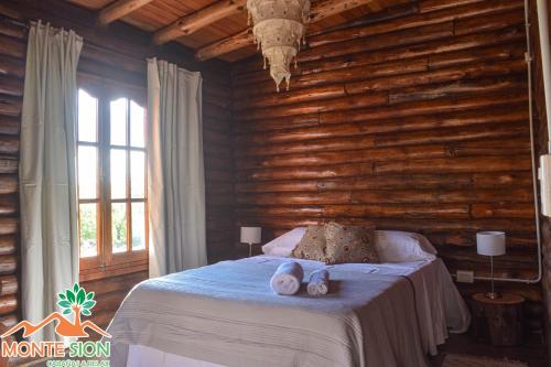 a bedroom with a bed with a wooden wall at Monte Sion cabañas & relax in San Javier