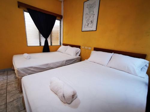 two beds sitting next to each other in a room at Natz Hotel in Flores