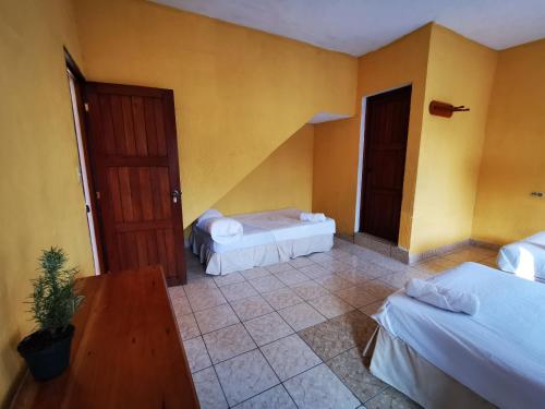 a hotel room with two beds and a door at Natz Hotel in Flores