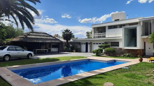una casa con piscina frente a ella en Casa Villa Nueva en Mendoza