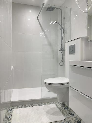 a white bathroom with a toilet and a shower at Cocon Cosy Flat - Hyper-Centre Senlis in Senlis