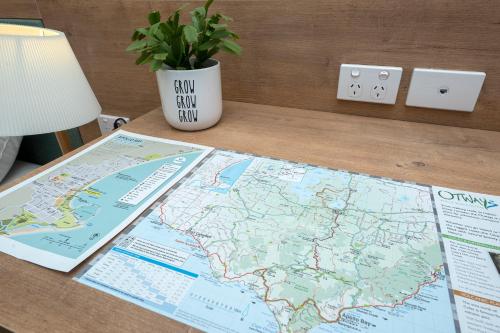 a table with a map and a vase with a plant at Blue Ocean Motel Apollo Bay in Apollo Bay