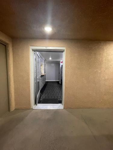 an empty hallway with a door leading to a room with a hallway at EL PATIO HOTEL in San Bernardino