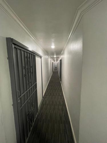 a hallway with a door and a long corridor at EL PATIO HOTEL in San Bernardino