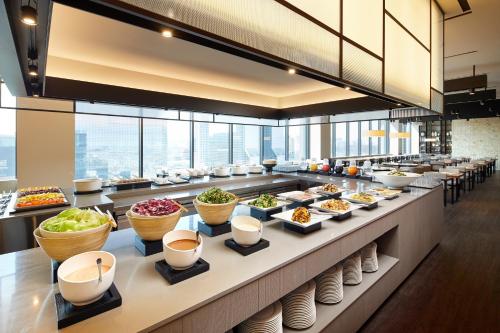 a buffet line with bowls of food on display at Shilla Stay Samsung COEX Center in Seoul