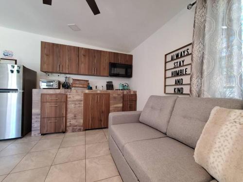 ein Wohnzimmer mit einem Sofa und einer Küche in der Unterkunft Aguadilla Sunset Apt AC WiFi 8 minute walk to Crashboat Beach in Aguadilla