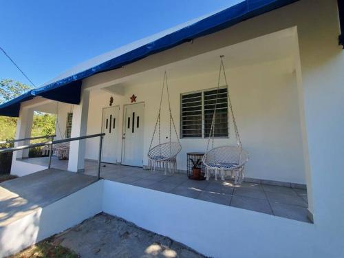 a porch of a house with two chairs at Aguadilla Sunset Apt AC WiFi 8 minute walk Crashboat Beach in Aguadilla
