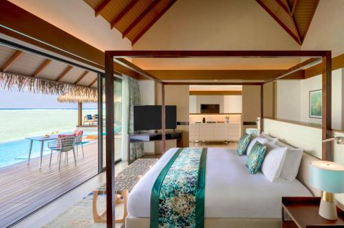 a bedroom with a bed and a view of the ocean at Pullman Maldives Maamutaa - All-Inclusive Resort - 50 percent off Transfers in Maamutaa