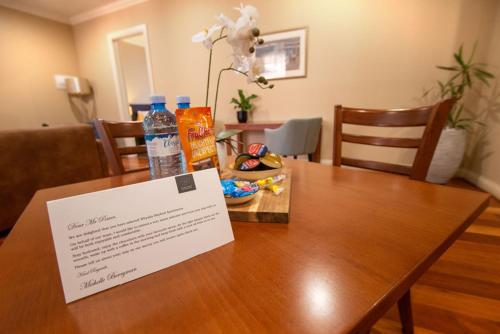 a sign on a wooden table with water bottles on it at Whyalla Playford Apartments in Whyalla