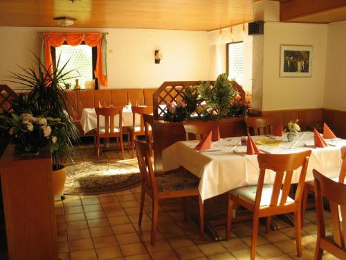 ein Restaurant mit Tischen und Stühlen in einem Zimmer in der Unterkunft Gasthaus zur Krone in Feilbingert