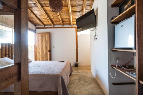 a bedroom with a bed and a flat screen tv at Vistazul in Vichayito