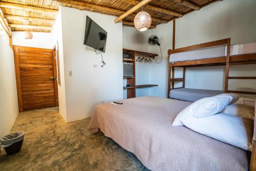 a bedroom with a bed and a flat screen tv at Vistazul in Vichayito