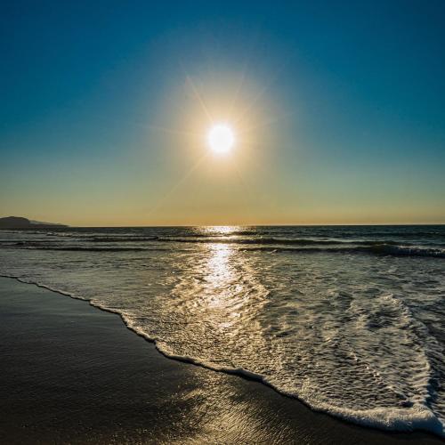 a beach with the sun rising over the ocean at Vistazul in Vichayito