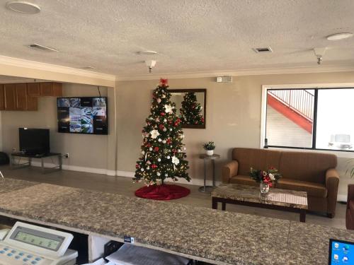 een kerstboom in het midden van een woonkamer bij Executive Inn & Suites in Beaumont