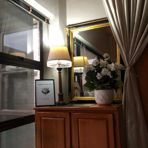 a lamp and a mirror on a dresser in a room at Wellington Country House in Wellington