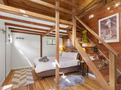 a bedroom with a bed in a room with wooden ceilings at Blue Apple Lodge in Bilpin