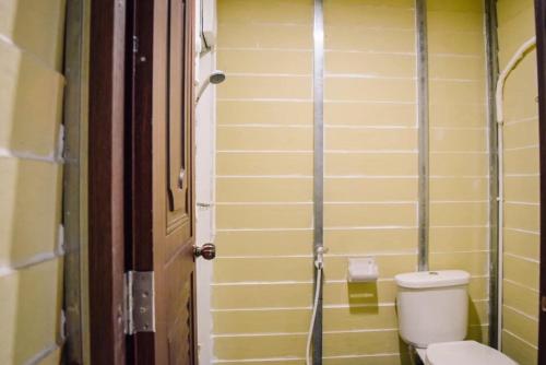a bathroom with a toilet next to a door at Ruanmai Style Resort 2 in Ban Nong Nam Khan