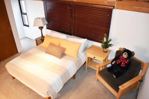 a bedroom with a bed with a teddy bear sitting on a chair at COZY Condo at Canyon Lodge! Sleeps 8, a walk to Canyon Lodge in Mammoth Lakes