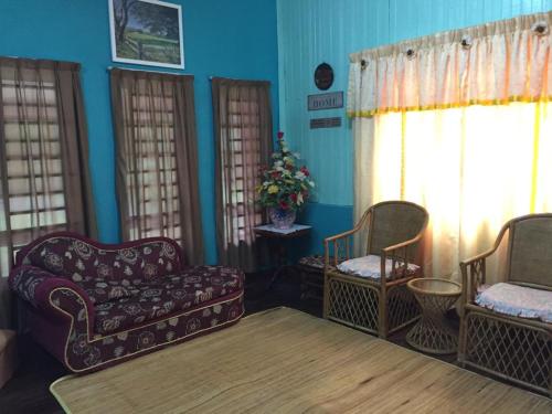 a living room with a couch and two chairs at Seri Pengkalan Homestay in Bachok