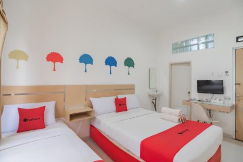 1 dormitorio con 2 camas y TV. en RedDoorz near Alun Alun Bandung 3, en Bandung
