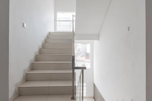 - un escalier dans une maison aux murs blancs dans l'établissement RedDoorz near Alun Alun Bandung 3, à Bandung