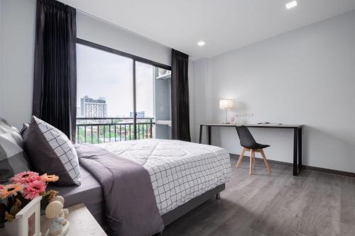 a bedroom with a bed and a desk with a window at Aqua Residences อควา เรสซิเดนซ์ ห้องพักใหม่ให้เช่า ติดรถไฟฟ้าสถานีวุฒากาศ in Bangkok