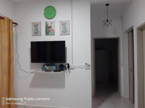 a living room with a tv on a white wall at MEDINA's 5STAR CondoSTAY in Nilai in Nilai