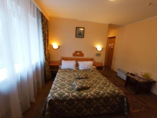 a hotel room with a bed with two pillows at Гостиница ИЛЕК in Aktobe