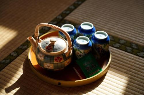 a tray with a tea pot and a group of soda cans at Guesthouse Maple Nikko in Nikko
