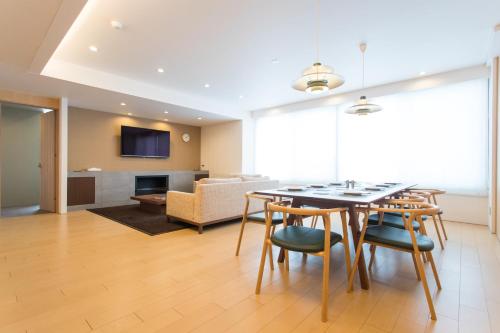 a living room with a table and chairs and a couch at hirafu188 in Kutchan