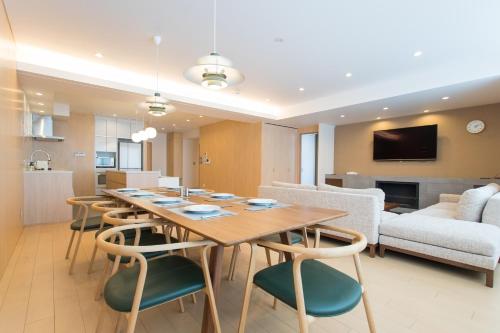a dining room and living room with a table and chairs at hirafu188 in Kutchan