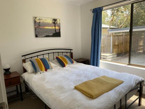 um quarto com uma cama grande e uma janela em Kyeema Free Wifi Netflix Pet Friendly Outside Only em Inverloch