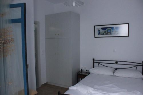 a bedroom with a bed and a tall cabinet at Casaprimavera in Katapola