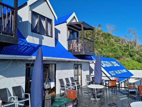 
a patio area with chairs, tables and umbrellas at Lagoon Lodge in Knysna
