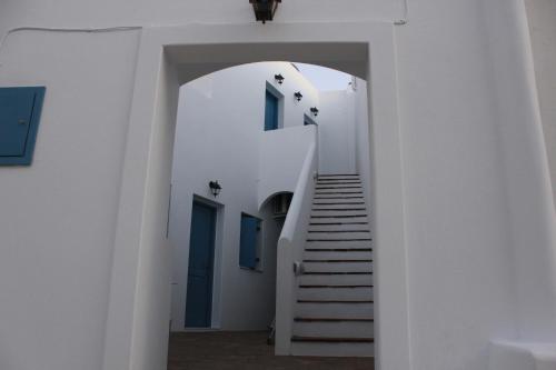 a staircase leading up to a white building with blue doors at Casaprimavera in Katapola