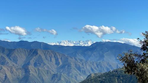 a view of mountains with clouds in the sky at Ananta Prana in Mussoorie