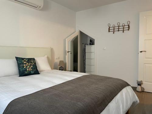 a bedroom with a white bed with a black pillow at Casa Gato Azul in Cómpeta