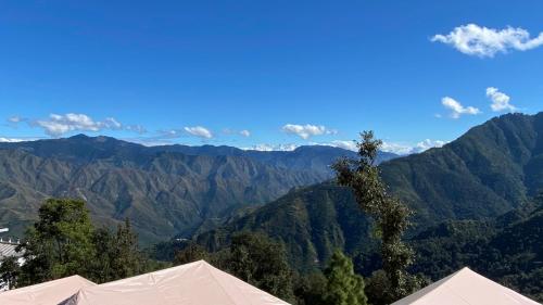a view of a mountain range with a tree at Ananta Prana in Mussoorie