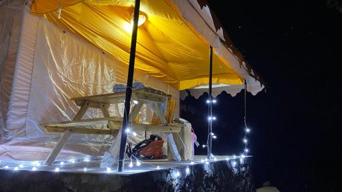 a yellow tent with lights under it at night at Ananta Prana in Mussoorie
