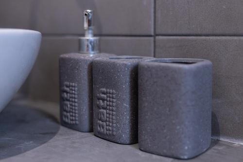 two gray soap dispensers sitting on a bathroom counter at verykokkos collection suites mikri vigla in Mikri Vigla