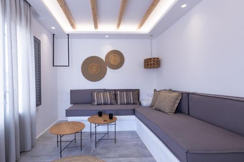 a living room with a blue couch and a table at verykokkos collection suites mikri vigla in Mikri Vigla
