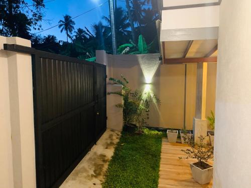 a backyard with a black gate and a fence at The Nook in Hikkaduwa