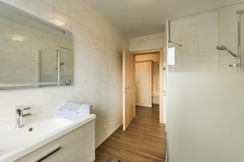 uma casa de banho com um lavatório e um chuveiro em Pension Schenkenfelder em Bad Häring