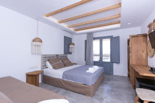 a bedroom with a bed and a desk and a television at verykokkos collection suites mikri vigla in Mikri Vigla