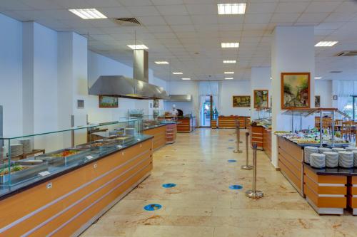 a large kitchen with counters and tables in a restaurant at Hotel Grand Efe in Ozdere