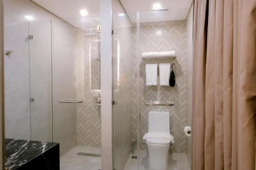 a bathroom with a toilet and a glass shower at Goldberry Suites and Hotel Cebu in Cebu City